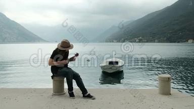 戴着帽子穿着破牛仔裤的女人坐在码头上弹吉他。